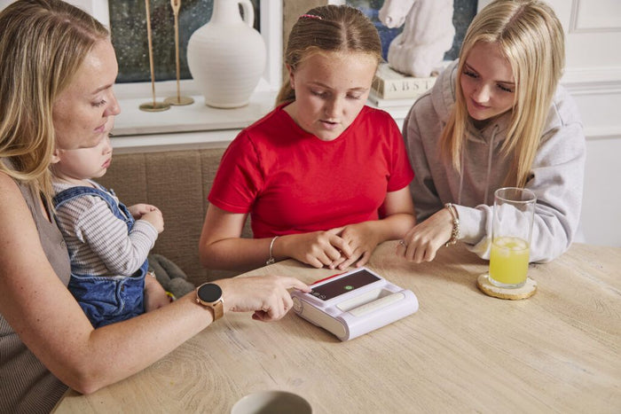 Family looking at the Elliot AED together at the kitchen table